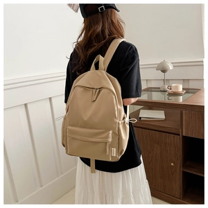 Detail of khaki nylon backpack with large capacity and adjustable straps on a model