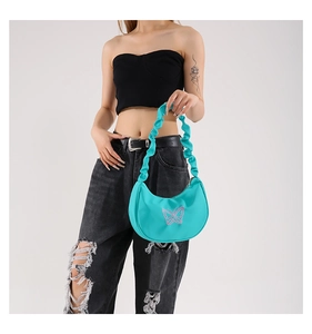 Detail of teal nylon moon bag with pink butterfly embroidery and ruffled cloud handle