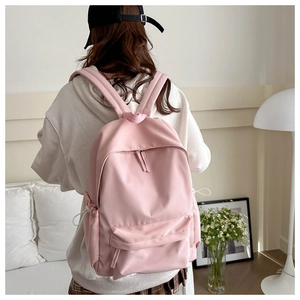 Pink Korean style backpack with drawstring side pockets shown in a cozy home setting