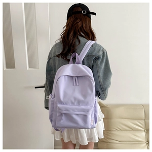 Detail of lavender nylon backpack with side drawstring pocket shown on a model