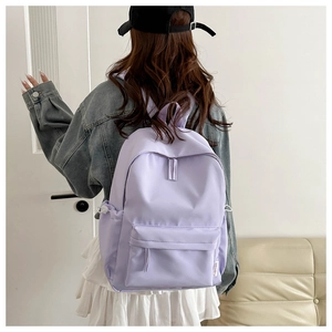 Detail of lavender nylon backpack featuring drawstring side pockets and fashion tag