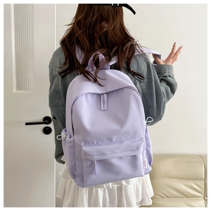 Detail of lavender school backpack showing side pocket with fashion label and bungee cord