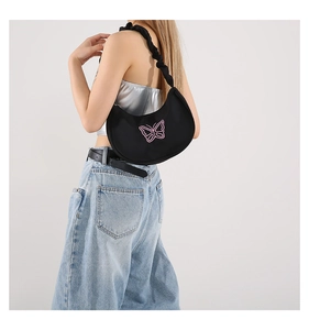 Detailed side view of black crescent underarm bag with pink butterfly embroidery
