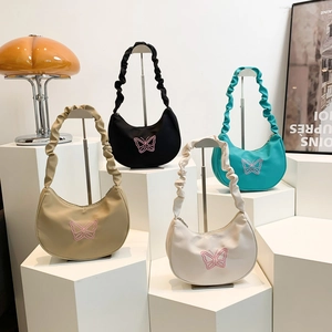 Fashionable butterfly embroidered shoulder bags in four colors on display stands