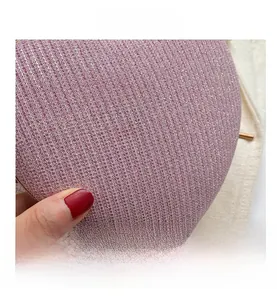 Detailed close-up of pink sequined texture and striped fabric on evening clutch bag