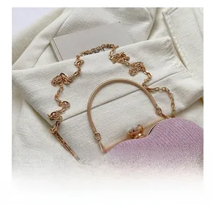 Detailed close-up of pink glitter heart evening bag with gold ring handles and chain
