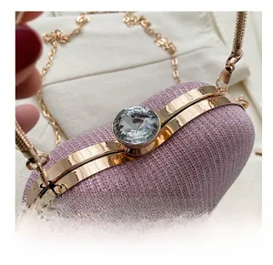 Detail of pink glitter evening bag featuring a large faux diamond clasp and gold hardware