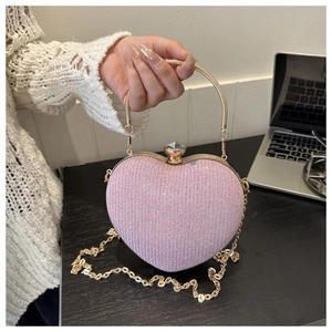 Detail of light pink heart-shaped evening bag with glitter surface and crystal clasp