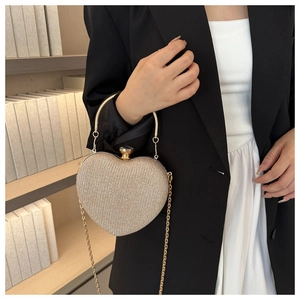 Detail of heart-shaped glitter evening clutch with crystal clasp and gold chain strap
