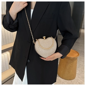 Detail of champagne gold heart clutch featuring glitter texture and metal chain strap