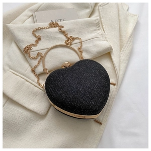 Close-up of glitter heart evening bag with gold ring handle and detachable chain
