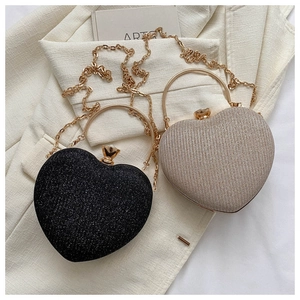 Detail of glitter heart-shaped evening bags with gold ring handles and chain straps