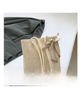 Detail of straw tote bag featuring heart print silk scarf and round rope handles
