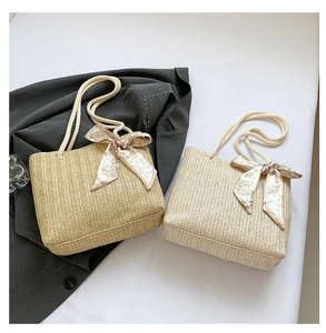 Detail of woven straw tote bags with thick rope handles and heart print silk scarves