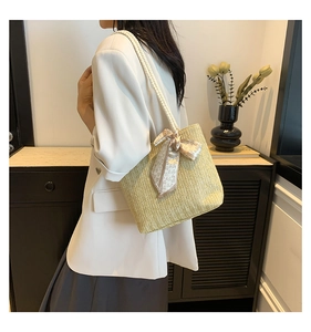 Detail of hand-woven straw tote with elegant heart-print silk scarf and sturdy rope handles