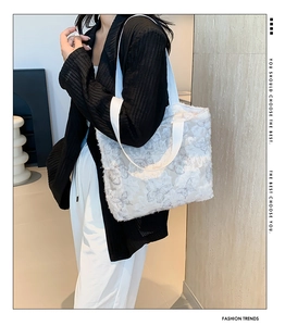 Detail of white butterfly tote bag with fuzzy texture worn by a model in casual style