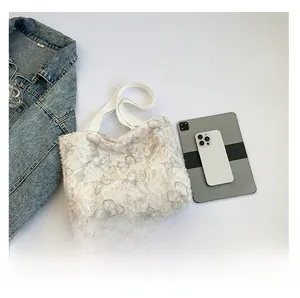 Size comparison of a white lace butterfly tote bag with an iPad and a phone