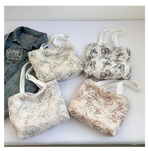 Detailed macro view of four butterfly patterned tote bags with unique 3D fringed texture