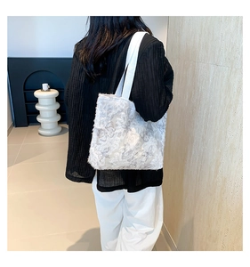 Close-up of white tote bag featuring 3D floral lace textures and woven shoulder strap