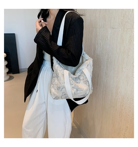 Detail of canvas tote bag featuring butterfly print and frayed fringe edge texture