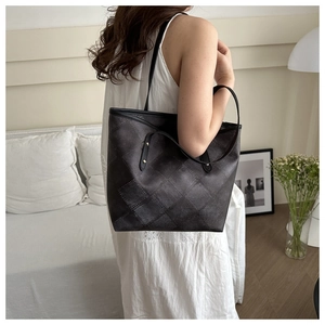 Charcoal grey large tote bag with vintage quilted texture shown on shoulder