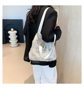Close-up of white jacquard tote bag with grey butterfly pattern and textured plush fabric