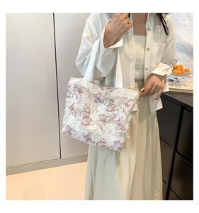 Detailed view of white canvas tote bag with delicate pink butterfly lace embroidery