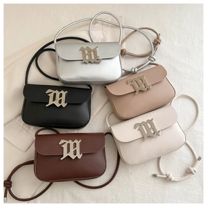 Flat lay of retro square crossbody bags in five colors with gothic M metal logo