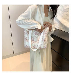 Detail of canvas tote bag with pink butterfly print and decorative tassel edge trim