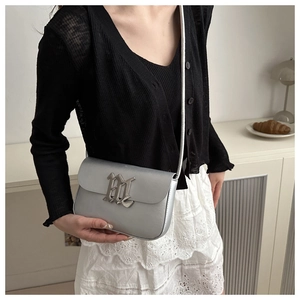 Minimalist silver metallic crossbody bag with industrial buckle detail and white strap