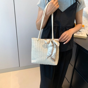 Minimalist beige woven tote bag for summer with heart scarf detail on shoulder strap