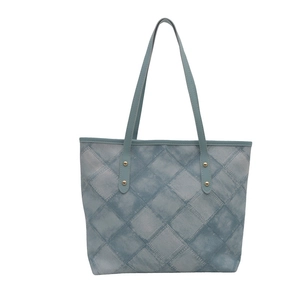 Minimalist light blue tote bag with denim texture and golden rivets on white background