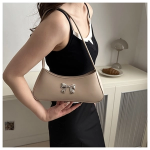 Detail of elegant shoulder bag with silver bow buckle and soft leather texture