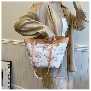 Detailed close-up of a pink butterfly print tote bag with slender leather shoulder straps
