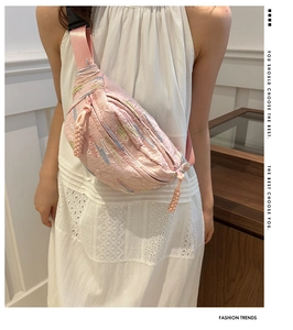 Détail du sac bandoulière rose avec broderies colorées et tirette de zip tissée