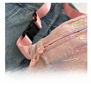 Détail du sac bandoulière rose avec broderie arc-en-ciel et fermeture éclair fluide