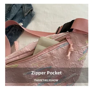 Gros plan sur le sac ceinture rose matelassé avec surpiqûres zigzag et poche zippée