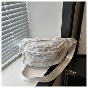 Détail du sac banane blanc avec texture gaufrée logo F et broderies ondulées colorées