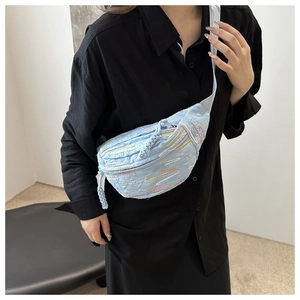 Détail du sac de poitrine plissé bleu clair avec broderies et sangle blanche