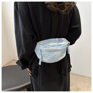 Détail de la sacoche banane bleu clair matelassée avec broderies porté par modèle
