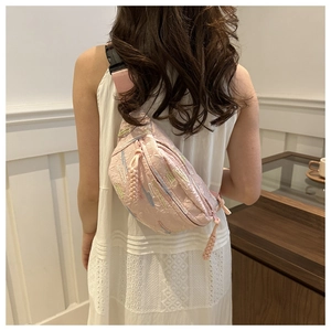 Vue arrière du sac bandoulière rose matelassé avec broderie sur un mannequin femme