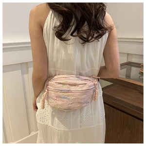 Détail du sac bandoulière rose avec broderie arc-en-ciel colorée et tissu à effet plissé