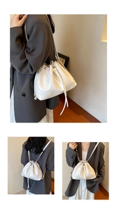 Close-up of white bucket bag showing multi-functional shoulder and backpack strap styles