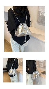 Silver metallic drawstring bucket backpack showing back and side views on model