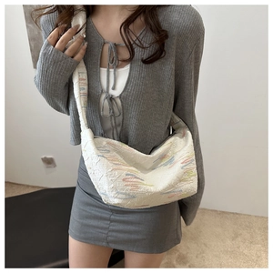 Detail of white jacquard shoulder bag with colorful wave embroidery on model