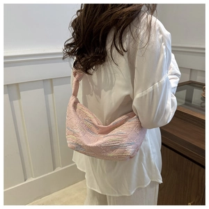 Detail of pink dumpling bag with colorful wave embroidery and stylish knotted handle