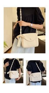 Detail of hand-woven straw crossbody bag featuring pearl button and lace ribbon bow
