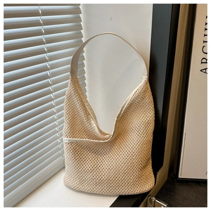 Detail of the woven texture and mesh pattern on a beige summer straw tote bag