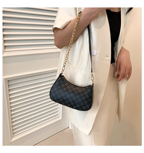 Detail of crescent shoulder bag with geometric patterns and golden chain strap