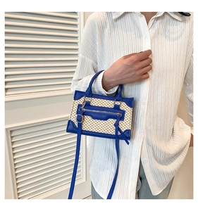 Détail du sac à main tissé beige avec bordures en cuir bleu et bandoulière réglable